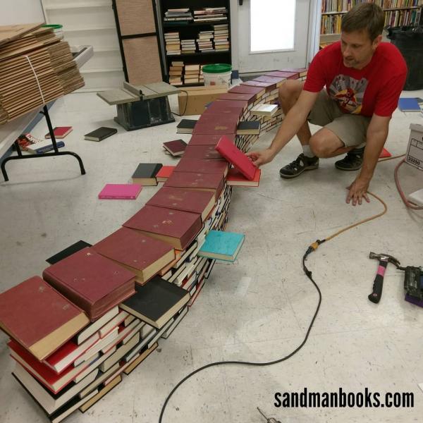 Scott Hill constructs the book arch.  Book Arch in Sandman Books Punta Gorda Florida. Florida Tourism Tourist Local Art Artist Artwork Fantasy Harry Potter Beauty and the Beast Disney Wedding Photography Unconventional Unique Venue Sell Used New Books Bookstore Bookshop Library  