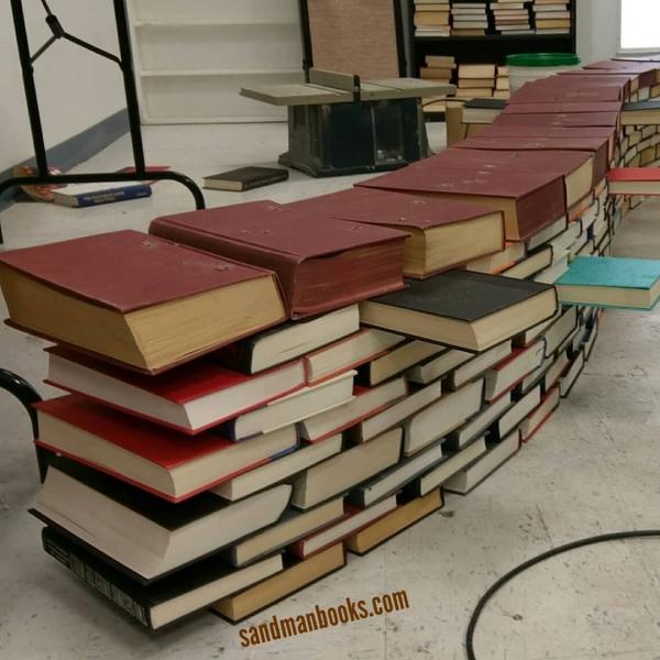 Books lined up on the floor, waiting to be used in the construction of the book arch.  Book Arch in Sandman Books Punta Gorda Florida. Florida Tourism Tourist Local Art Artist Artwork Fantasy Harry Potter Beauty and the Beast Disney Wedding Photography Unconventional Unique Venue Sell Used New Books Bookstore Bookshop Library  