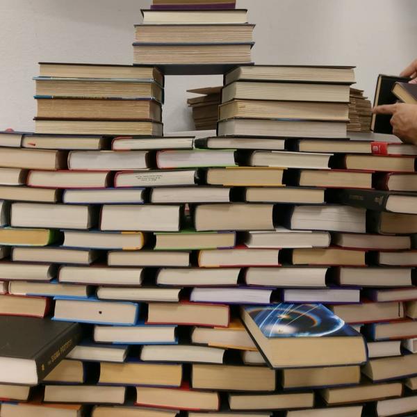 Books stacked to be used in the construction of the book arch.  Book Arch in Sandman Books Punta Gorda Florida. Florida Tourism Tourist Local Art Artist Artwork Fantasy Harry Potter Beauty and the Beast Disney Wedding Photography Unconventional Unique Venue Sell Used New Books Bookstore Bookshop Library  