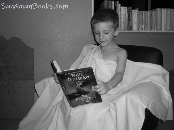 A young boy reads The Graveyard Book by Neil Gaiman. Sandman Books Punta Gorda Florida Bookstore Local Tourism Tourist Vacation Bookshop Library Sell New Used Books Tourist